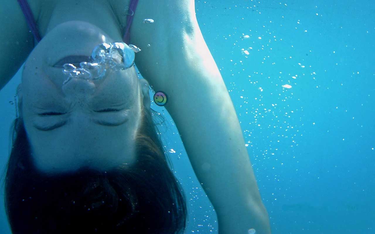 Аквалангистка красуется пилоткой под водой
