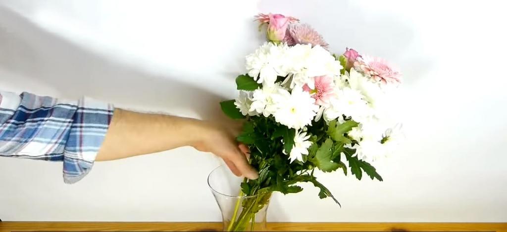 Цветы ставить в холодную или теплую. Лайфхак как устанавливать цветы в вазу. Парень ставит цветы в вазу. Девушка ставит цветы в вазу. Во что временно поставить цветы.