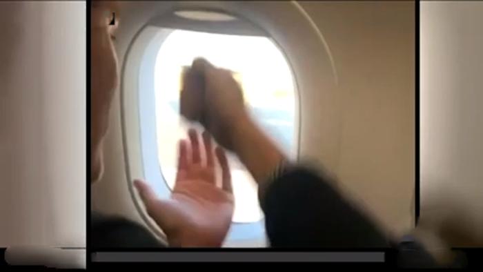 Пассажир и служащий аэропорта играют в  Камень ножницы бумага  через иллюминатор самолета (видео)