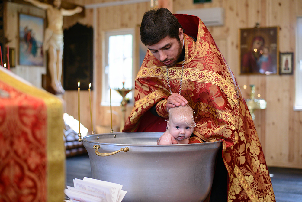 Крестят ли детей на пасху. Крещение младенца. Крещение младенцев в православии. Крещение младенца в православном храме. Священник крестит ребенка.