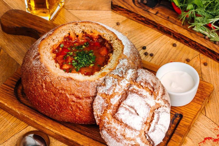 Необычная подача блюда. Хлебная чаша, покрытая аппетитным расплавленным сыром наполнена сытным томатным супом