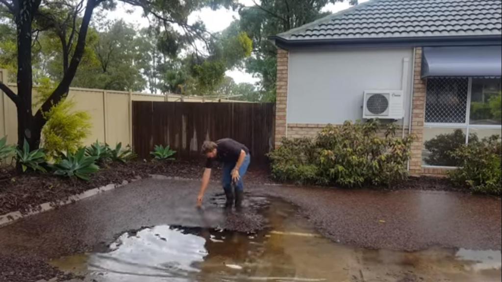 После сильного дождя парень вышел во двор, нашел дренажную решетку и поднял ее (видео)