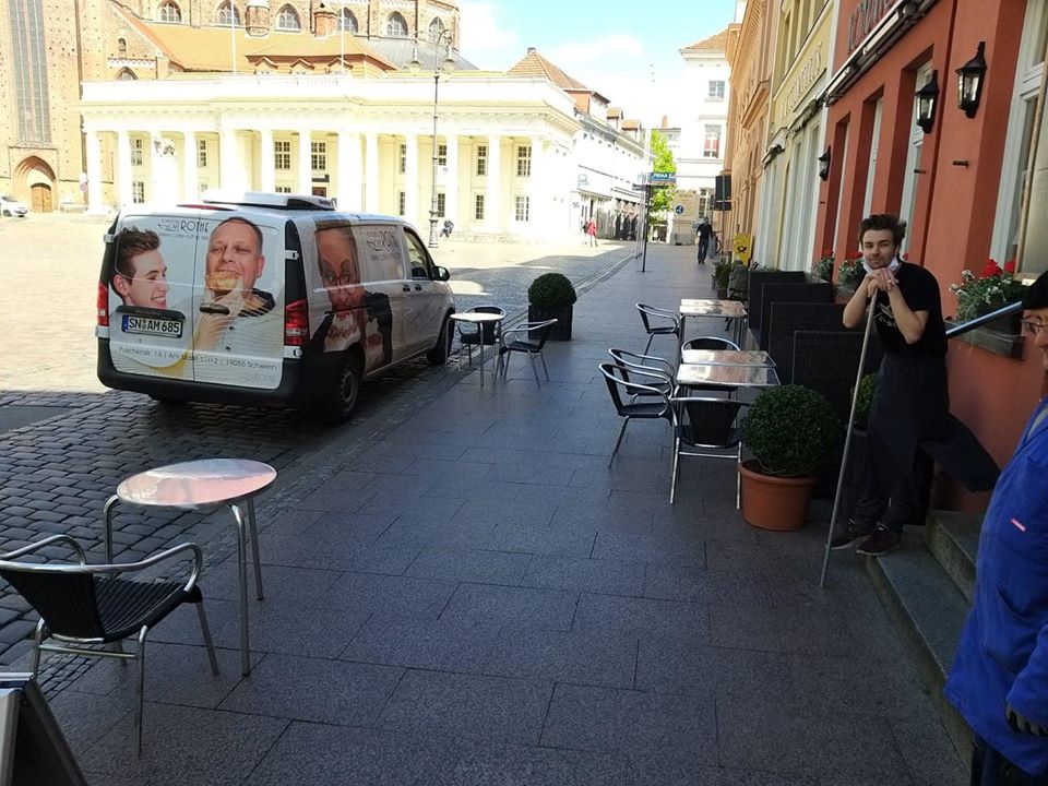 Открывшееся после ослабления ограничений кафе в Германии предоставляет клиентам защитные шляпы с 