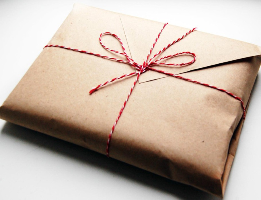 Завернуть подарок в оберточную. Упаковка в крафт бумагу. Бумага для упаковки подарков. Упаковка подарков в упаковочную бумагу. Упаковка подарка в крафт бумагу.